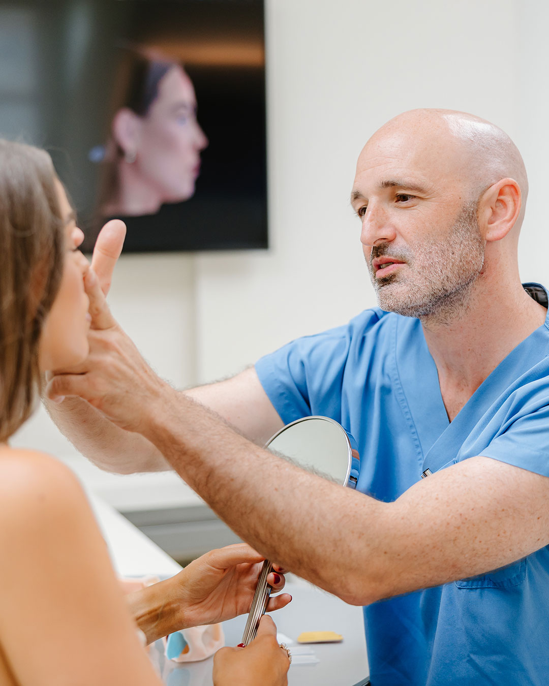 Dr Christoph Grill pointing out hooded eyelids on a patient — Kuzbari Centre Vienna
